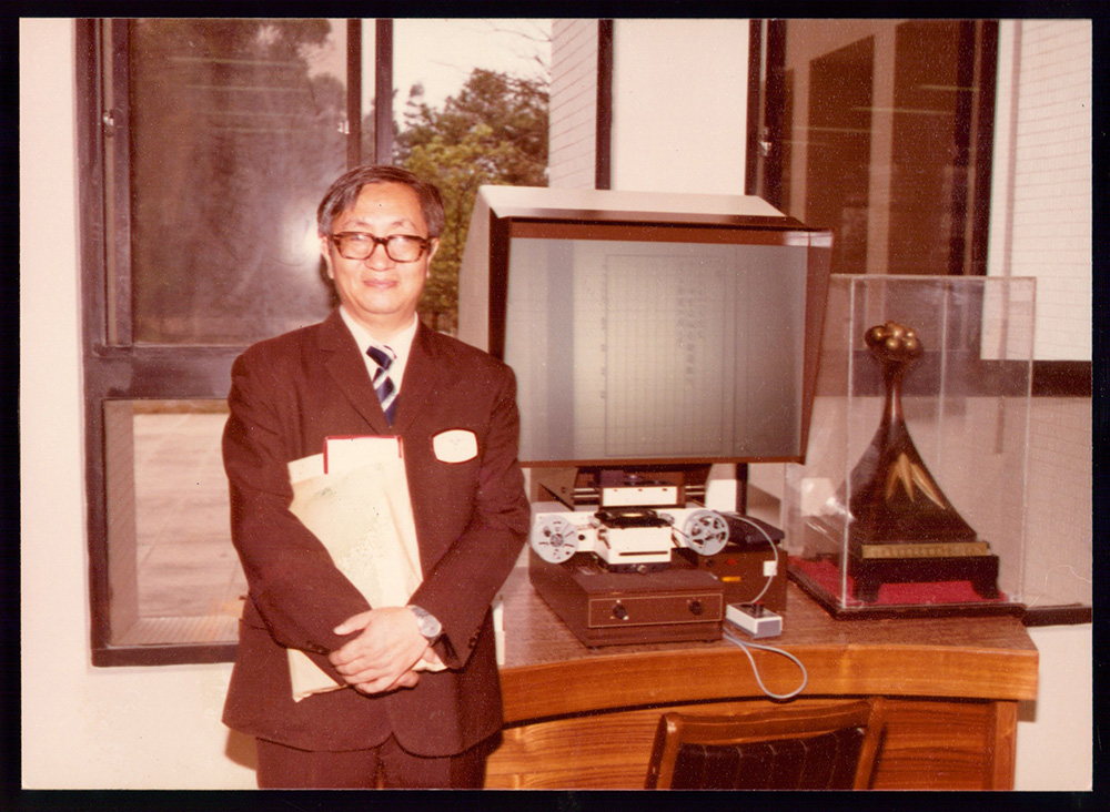 楊覺民教授於校史館獨照，一旁為展出梅校長日記的顯微機。